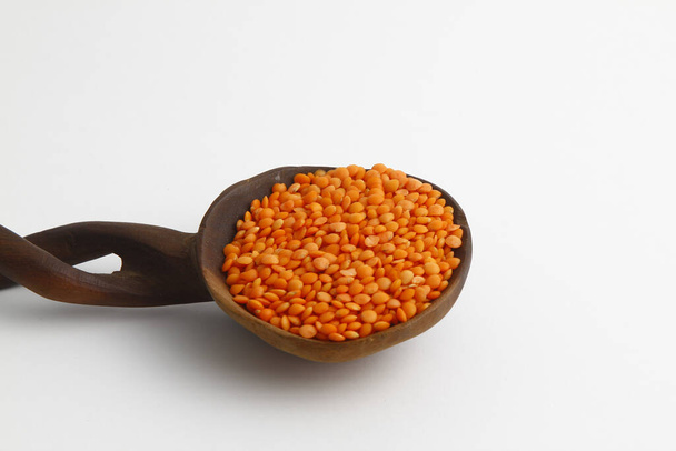 red lentils in wooden spoon isolated on white background. Top view. - Photo, Image