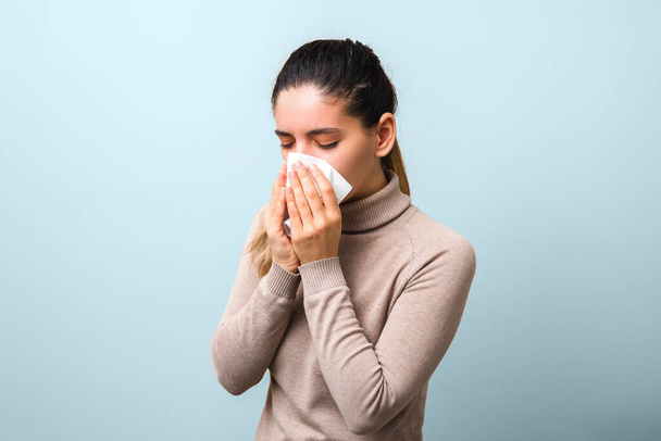 stop spreading coronavirus. young sick woman with fly or virus sneezing and coughing in a mask or napkin looking very hopeless. - Foto, Bild