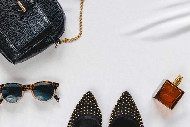 Zapatos y accesorios para mujer: bolso, perfume, gafas sobre fondo claro. Vista superior. Accesorios de fiesta con estilo
. - Foto, imagen