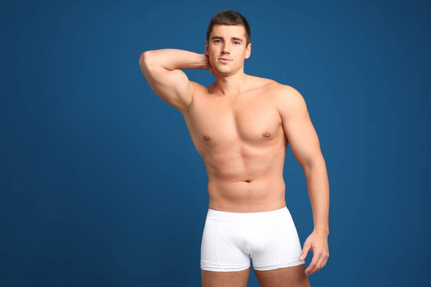 Man with sexy body on blue background - Foto, Imagen