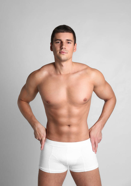 Man with sexy body on light background - Foto, Imagen
