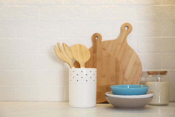 Wooden boards and different kitchen items on countertop indoors - 写真・画像