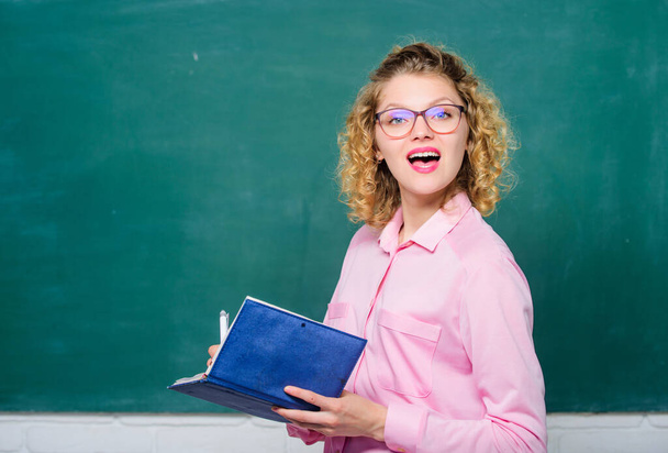 Passionate about knowledge. Pedagogue hold book and explaining information. Education concept. Teacher explain hard topic. Teacher best friend of learners. Woman school teacher in front of chalkboard - Фото, зображення