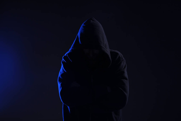 Mann mit Kapuze auf dunklem Hintergrund. Cyberkriminalität - Foto, Bild
