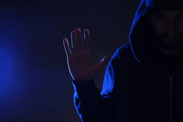 Man in hood on dark background. Cyber crime - Photo, image