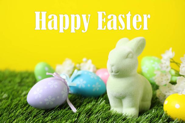 Easter bunny toy and dyed eggs on green grass - Foto, Imagen