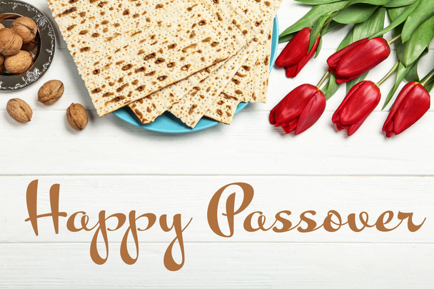 Flat lay composition with matzos on white wooden background. Passover (Pesach) celebration - Fotó, kép