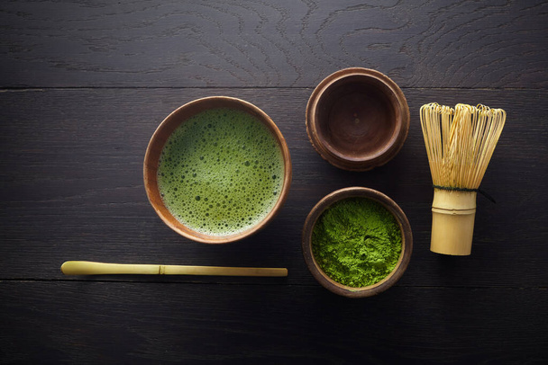 Matcha powder. Organic green matcha tea ceremony. Healthy drink. Traditional japanese drink on black wooden background - Foto, immagini