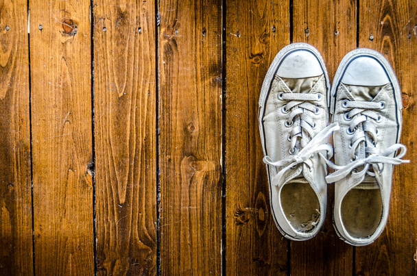 White Womans Canvas Sneakers op hardhouten vloer - Foto, afbeelding
