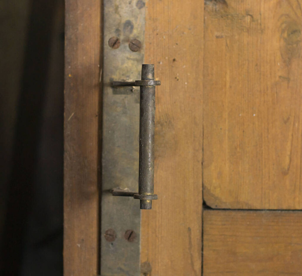 αντικέ πόμολο σε μια παλιά ανοιχτή πόρτα ενός παλιού εξοχικού σπιτιού. κοντινό πλάνο - Φωτογραφία, εικόνα