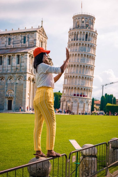 γυναίκα επισκεφθείτε τον πύργο της Πίζας, Γείτονας πύργος της Πίζας, Ιταλία με Βασιλική και τον καθεδρικό ναό σε μια φωτεινή καλοκαιρινή μέρα  - Φωτογραφία, εικόνα