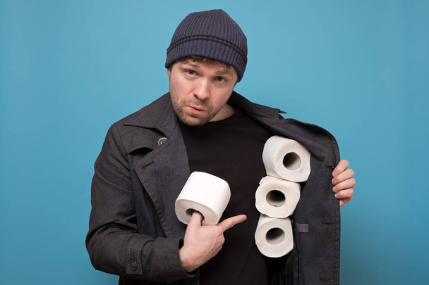 Молодий кавказький спекулянт тримає кілька рулонів туалетного паперу. Хочете купити його концепцію. Дефіцит в магазинах через коронавірусну паніку
 - Фото, зображення