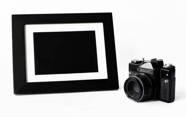 κάμερα και κορνίζα σε λευκό φόντο, κοντινό - Φωτογραφία, εικόνα