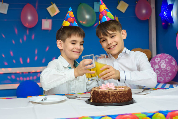 Due fratelli che scopano bicchieri di succo a una festa di compleanno
 - Foto, immagini