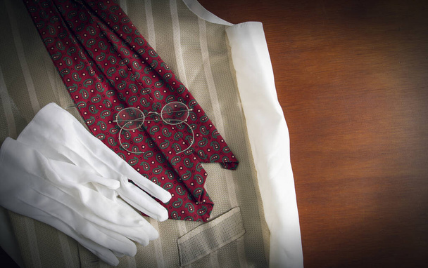 Herrasmiehen liivi, kravatti, käsineet ja lasit puupinnalla
 - Valokuva, kuva