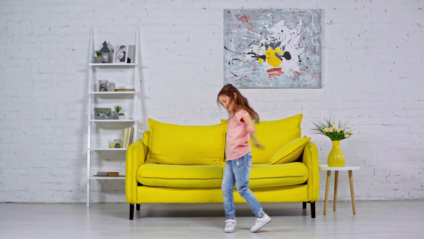 roztomilý dítě tanec v moderním obývacím pokoji  - Záběry, video