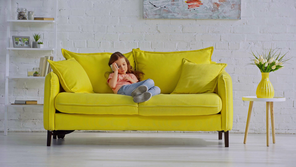 enfant heureux parlant sur smartphone tout en étant assis sur le canapé
  - Séquence, vidéo