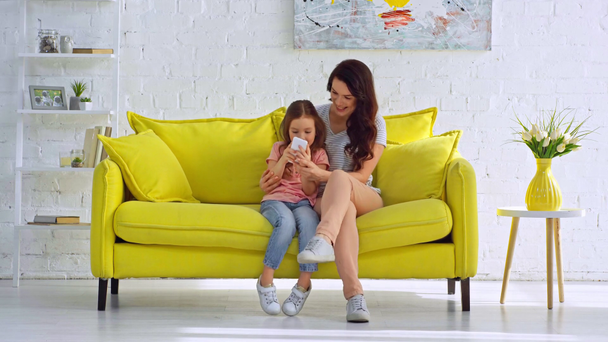 boldog anya és lánya szelfit csinálnak a nappaliban  - Felvétel, videó