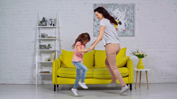 Glückliche Mutter und Kind tanzen im Wohnzimmer  - Filmmaterial, Video