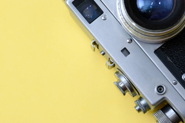 old classic retro camera on yellow background close-u - Foto, afbeelding