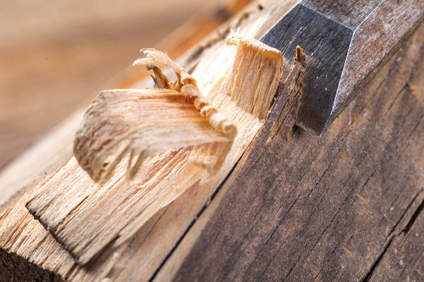 Chisel work in wood and raw wood shavings. Tools and accessories in a carpentry shop. Workplace carpentry workshop. - 写真・画像