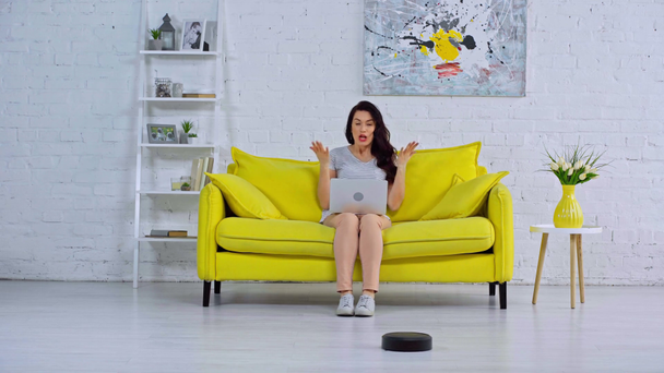 happy woman having video call near robotic vacuum cleaner - Footage, Video