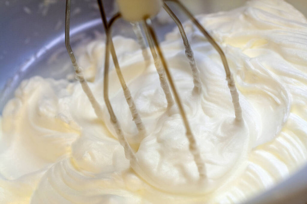 ボウルに白い卵クリームを電気ミキサーにかけ、ケーキを焼く - 写真・画像