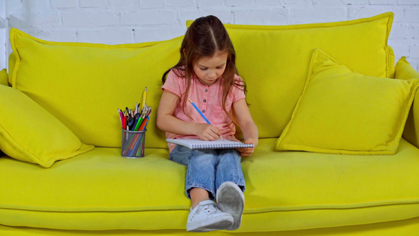 cute kid drawing while sitting in living room  - Video