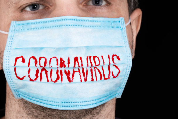 Retrato de um homem doente usando máscara médica em fundo preto. Conceito de coronavírus
. - Foto, Imagem