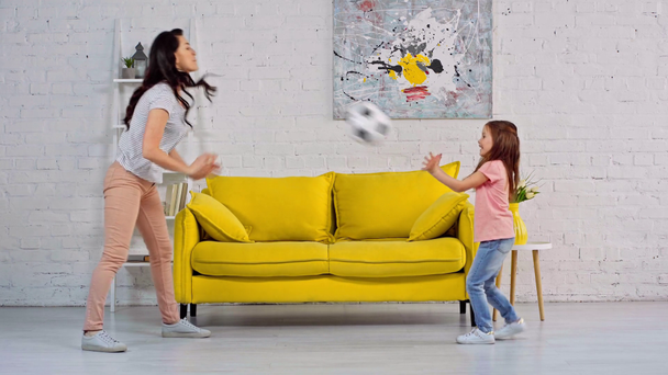 mother and daughter playing soccer in living room  - Footage, Video