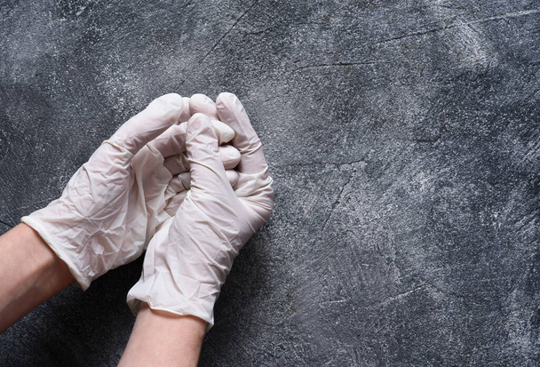Hands in medical gloves on a concrete background. Sterile gloves. Protection against germs. - Foto, afbeelding
