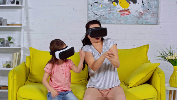 mother and daughter in virtual reality headsets at home  - Footage, Video