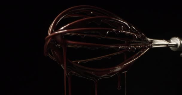 Καυτή σοκολάτα τήξη και ρίψη κάτω από ένα Whisk σε μαύρο φόντο Shot σε κόκκινο  - Πλάνα, βίντεο