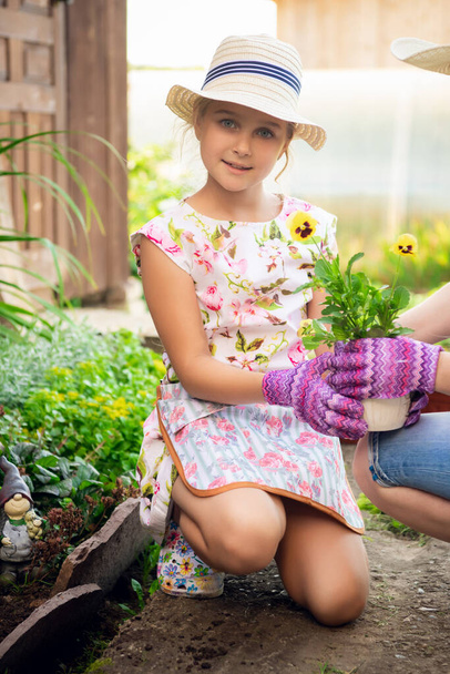 Kaunis pieni puutarhuri kukkaruukku käsissään
 - Valokuva, kuva