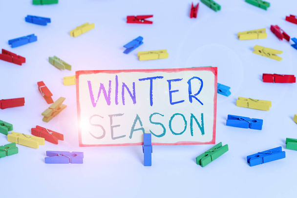 冬の季節を示すメモを書く。極と温帯地域で今年の最も寒い季節を紹介するビジネス写真色の布の紙空のリマインダ白い床の背景オフィス. - 写真・画像