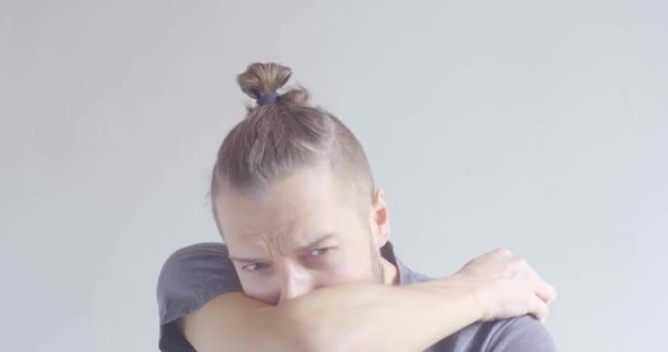 Fiatal szőke haj kaukázusi férfi Tüsszentés a karján - Felvétel, videó