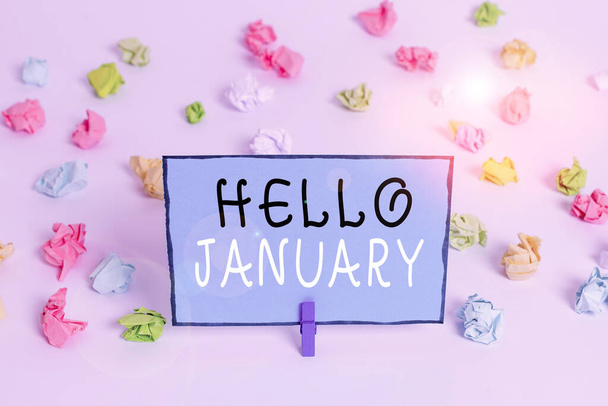 Text sign showing Hello January. Conceptual photo a greeting or warm welcome to the first month of the year Colored crumpled papers empty reminder white floor background clothespin. - Photo, Image