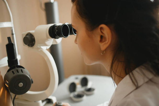 Female doctor studying medical tests in the microscope in a laboratory. - Valokuva, kuva