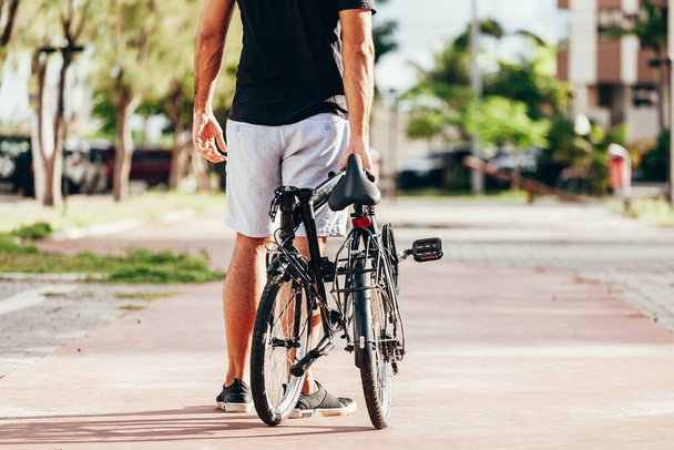 Młody człowiek wyciągając swój składany rower na zewnątrz - Zdjęcie, obraz