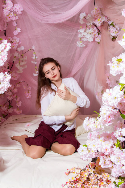 Meisje in de slaapkamer op het versierde bed - Foto, afbeelding