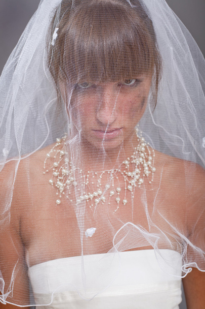 triest bruid onder witte sluier - Foto, afbeelding