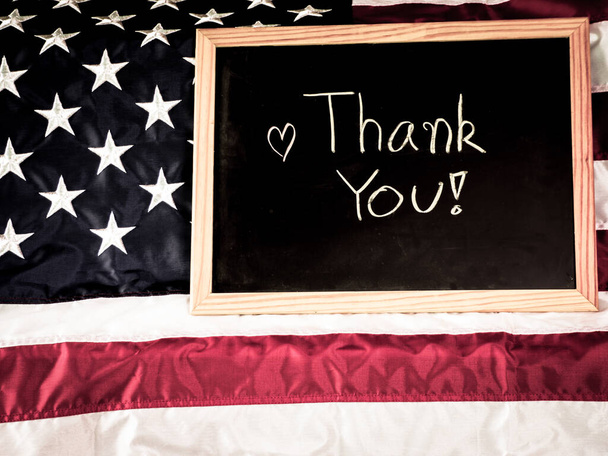 A mensagem Obrigado escrito em um quadro-negro ou quadro-negro com bandeira dos Estados Unidos da América. Conceito de dia militar ou independente veterinário
. - Foto, Imagem