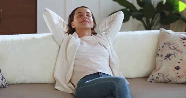 Sonriente joven perezosa relajándose apoyada en un cómodo sofá
 - Metraje, vídeo