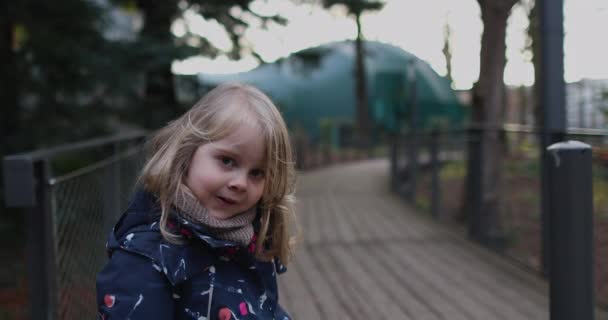A little girl in a ROSE dress runs away from the camera - Imágenes, Vídeo