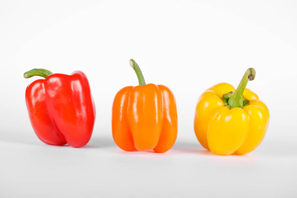 Red, orange and yellow color peppers on white background - Foto, Imagem