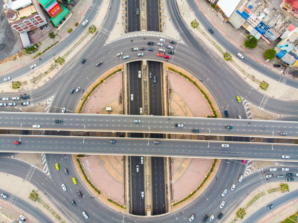 Vista superior aérea cruce circular transporte de la ciudad carretera con el movimiento del coche puesta de sol - Foto, Imagen