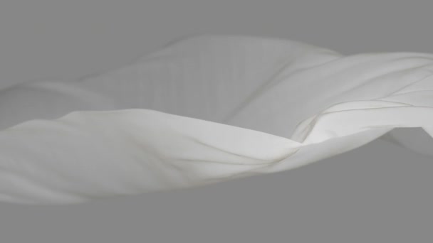 4k bianco tessuto di seta ondulato nel vento, senza soluzione di continuità sventolando bandiera sfondo del ciclo del panno. - Filmati, video