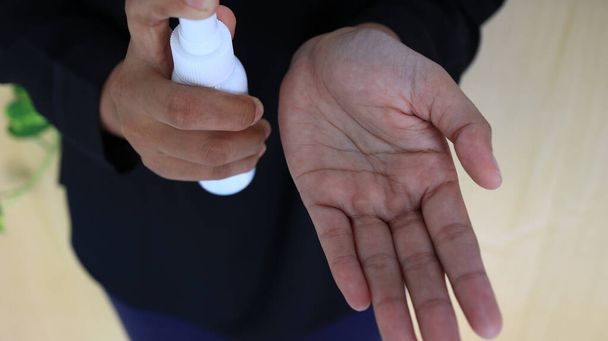 Ongefocust, wazig selectief focusbeeld van spray desinfecterende vloeistof in de handen, om het virus te doden - Foto, afbeelding