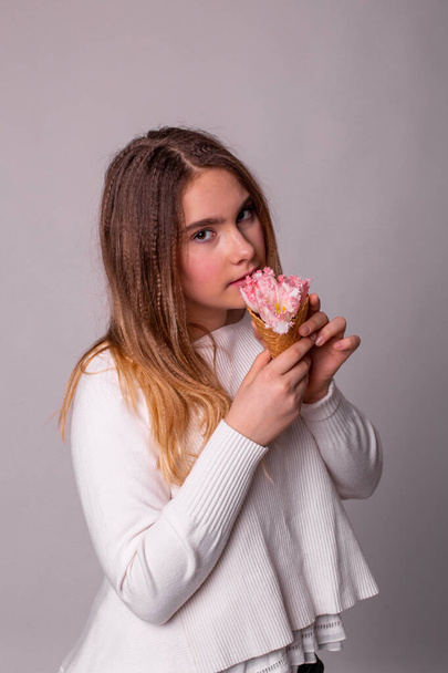 menina com cabelo longo come sorvete de flores
 - Foto, Imagem