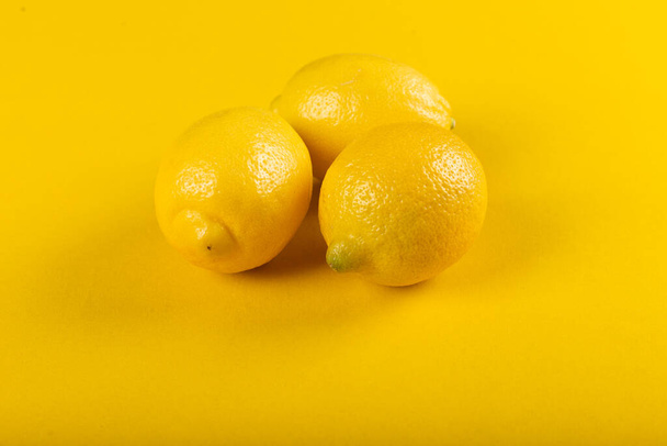 Yellow lemons isolated on a yellow background.  - Foto, Imagem